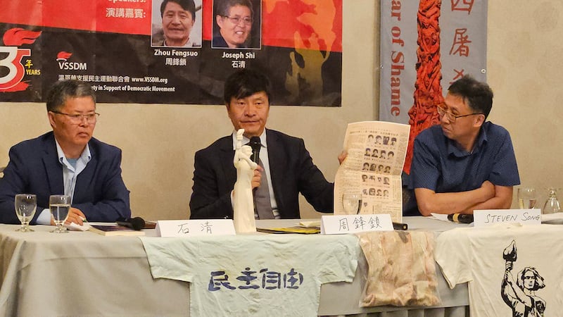 有年轻一代提问当年六四的学运领袖后来的动向,周锋锁(中)拿着当年北京当局公布的21人通缉名单,说明他们近况,也鼓励年轻一代接棒,继续为中国民主努力。(记者柳飞拍摄)